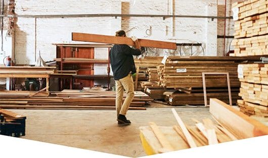 Man Carrying Timber — Premium Pegs for Surveying & More in Heatherbrae, NSW